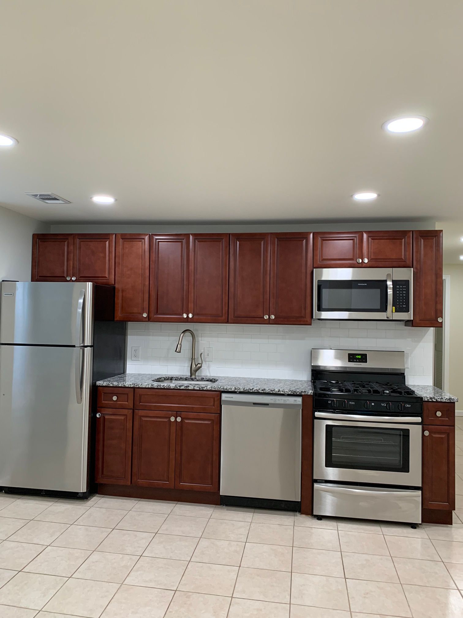 A kitchen with stainless steel appliances and wooden cabinets