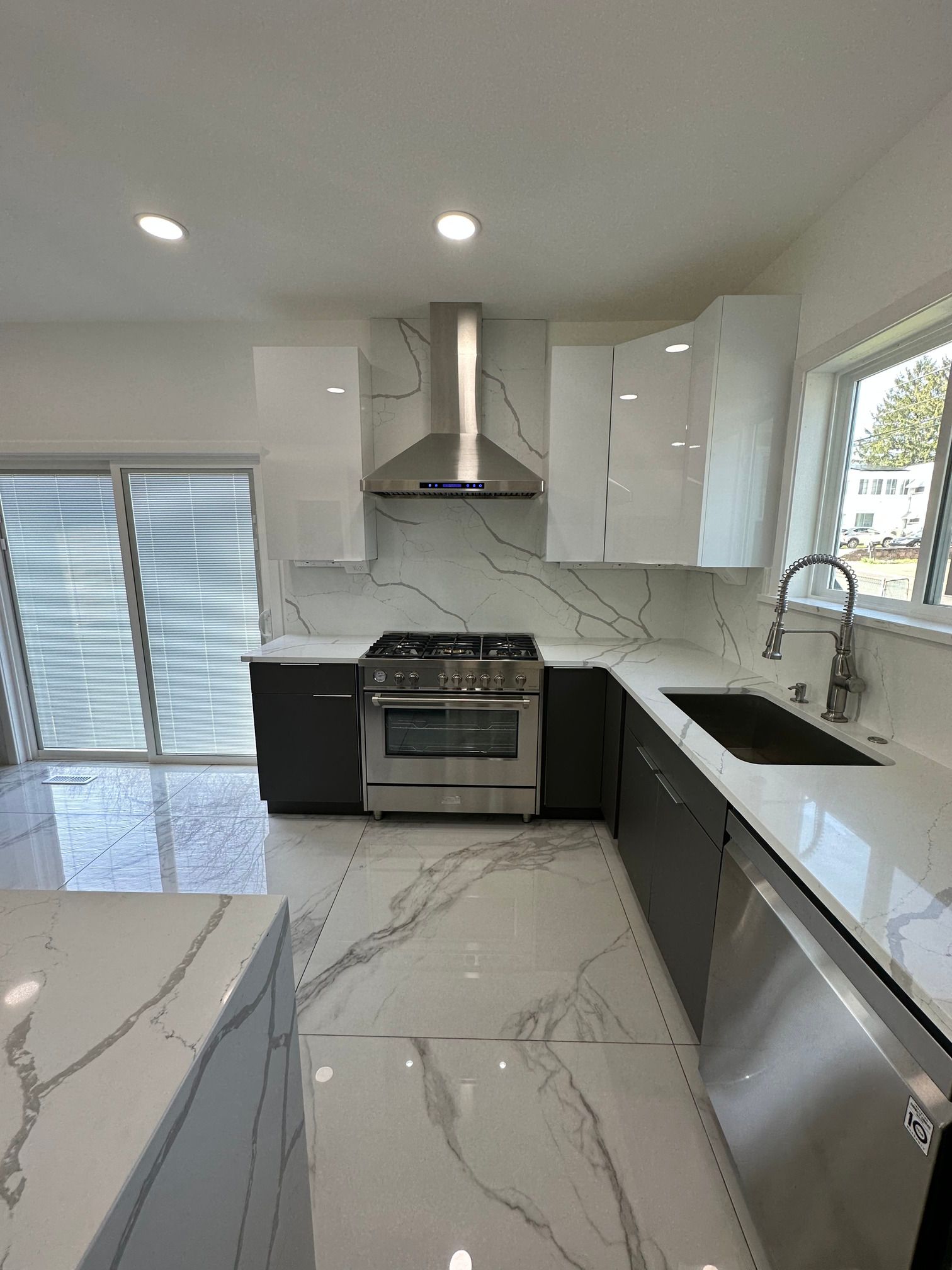 A kitchen with a stove , sink , and dishwasher.