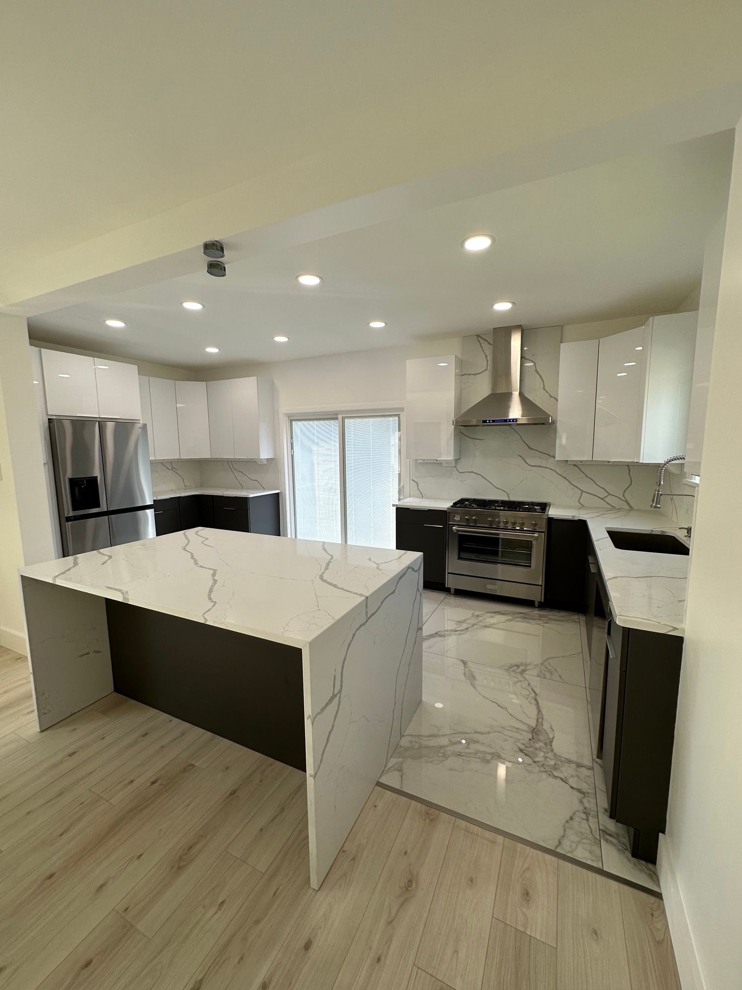 A kitchen with a large island and stainless steel appliances.