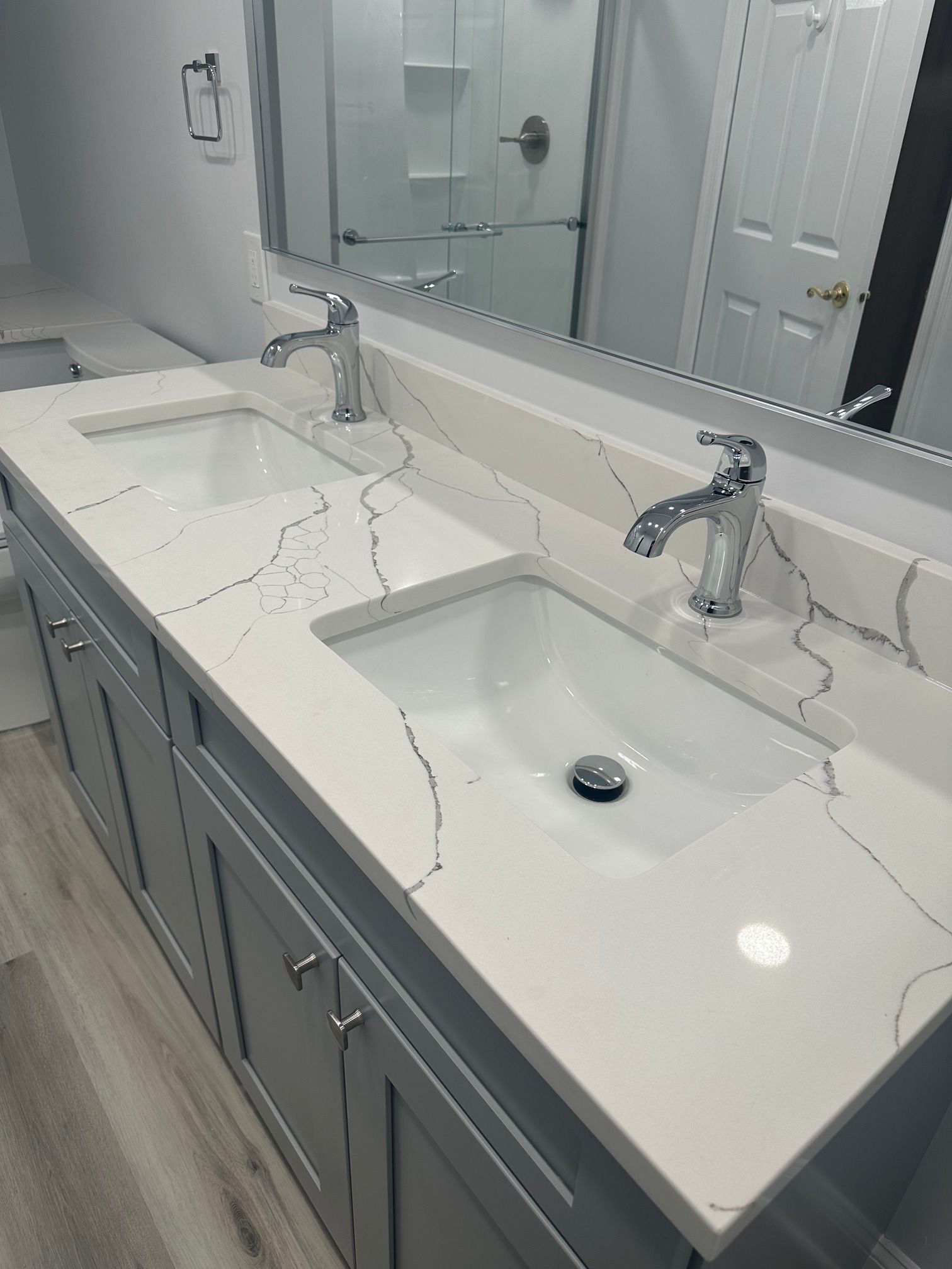 A bathroom with two sinks and a large mirror.