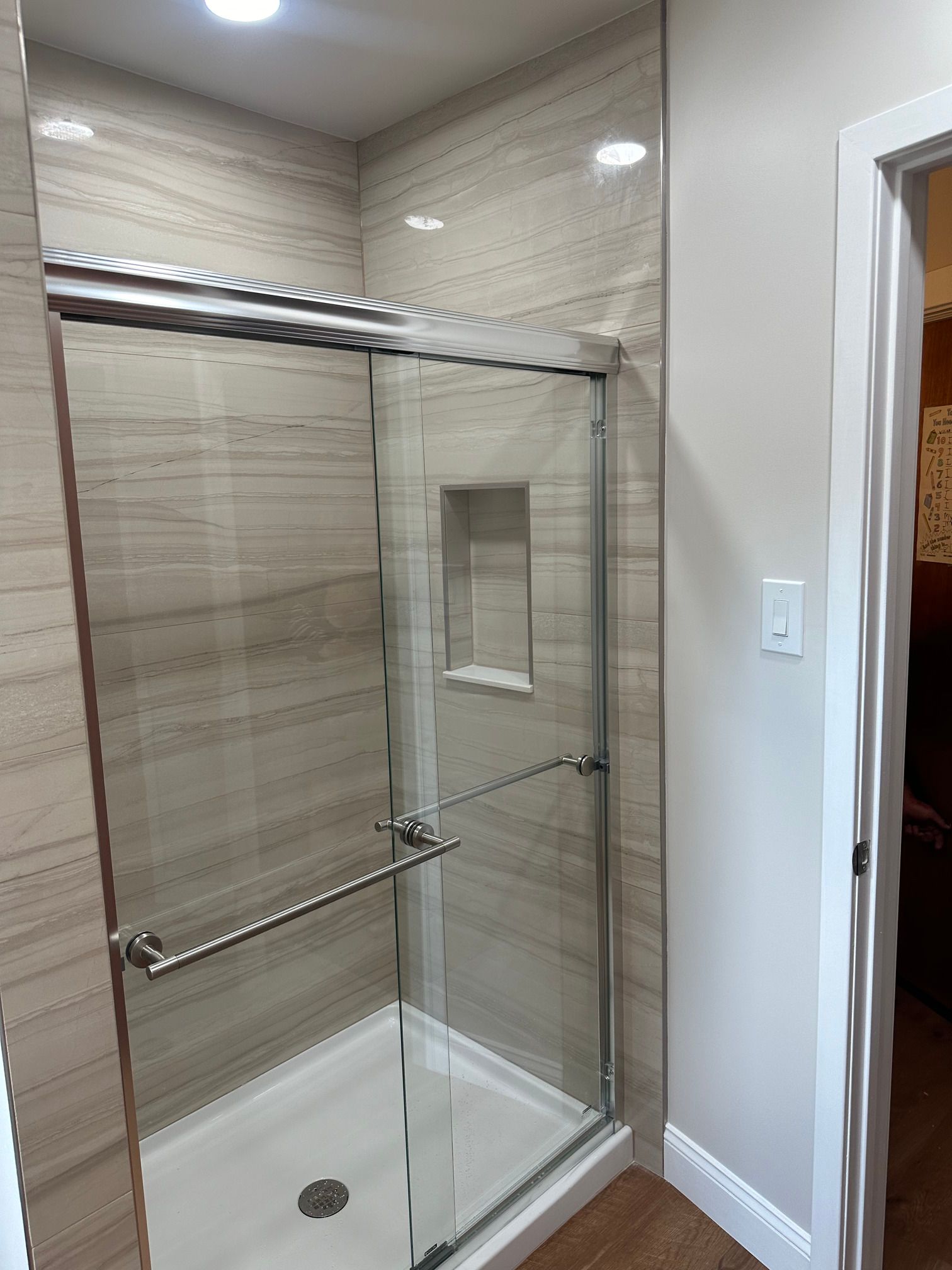 A bathroom with a sliding glass shower door.