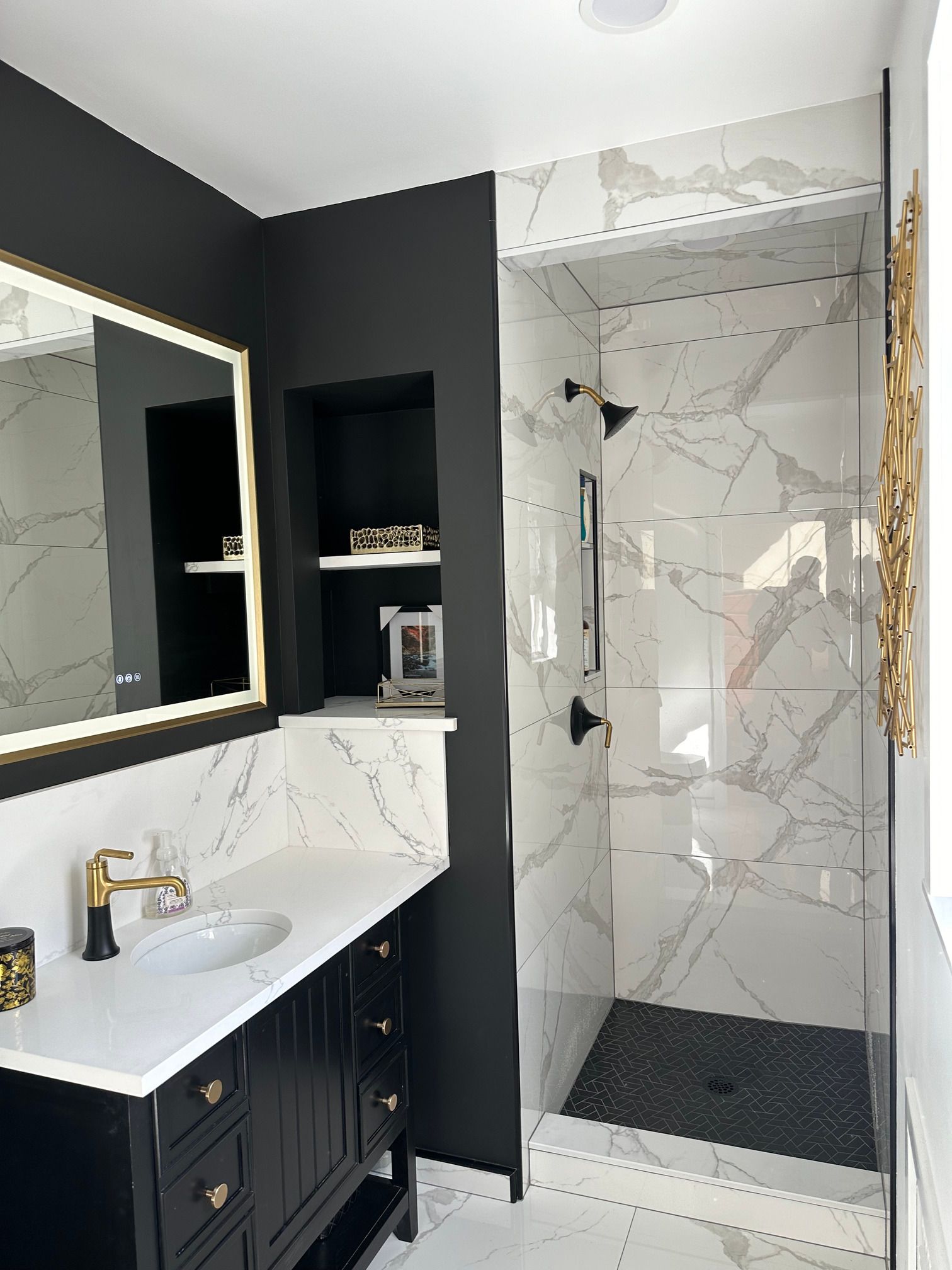 A bathroom with a sink , mirror , and walk in shower.