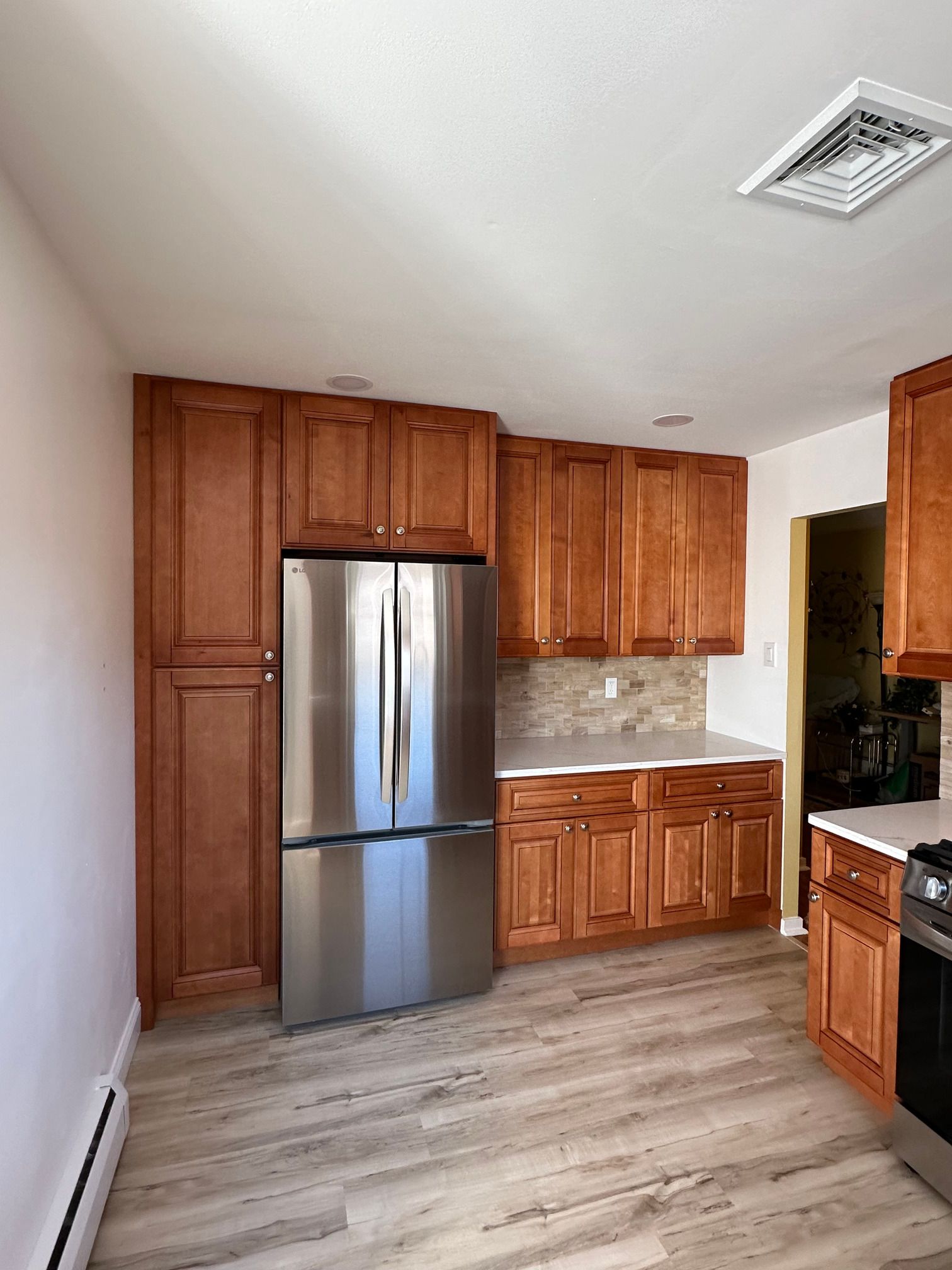 A kitchen with stainless steel appliances and wooden cabinets.