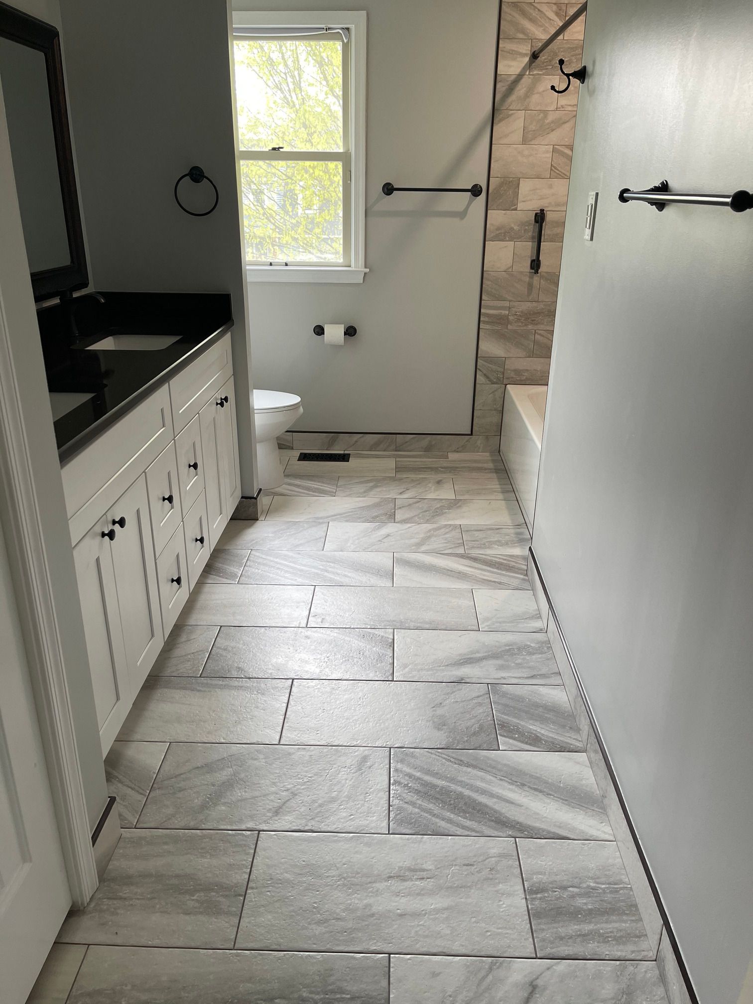 A bathroom with a toilet , sink , mirror and shower.