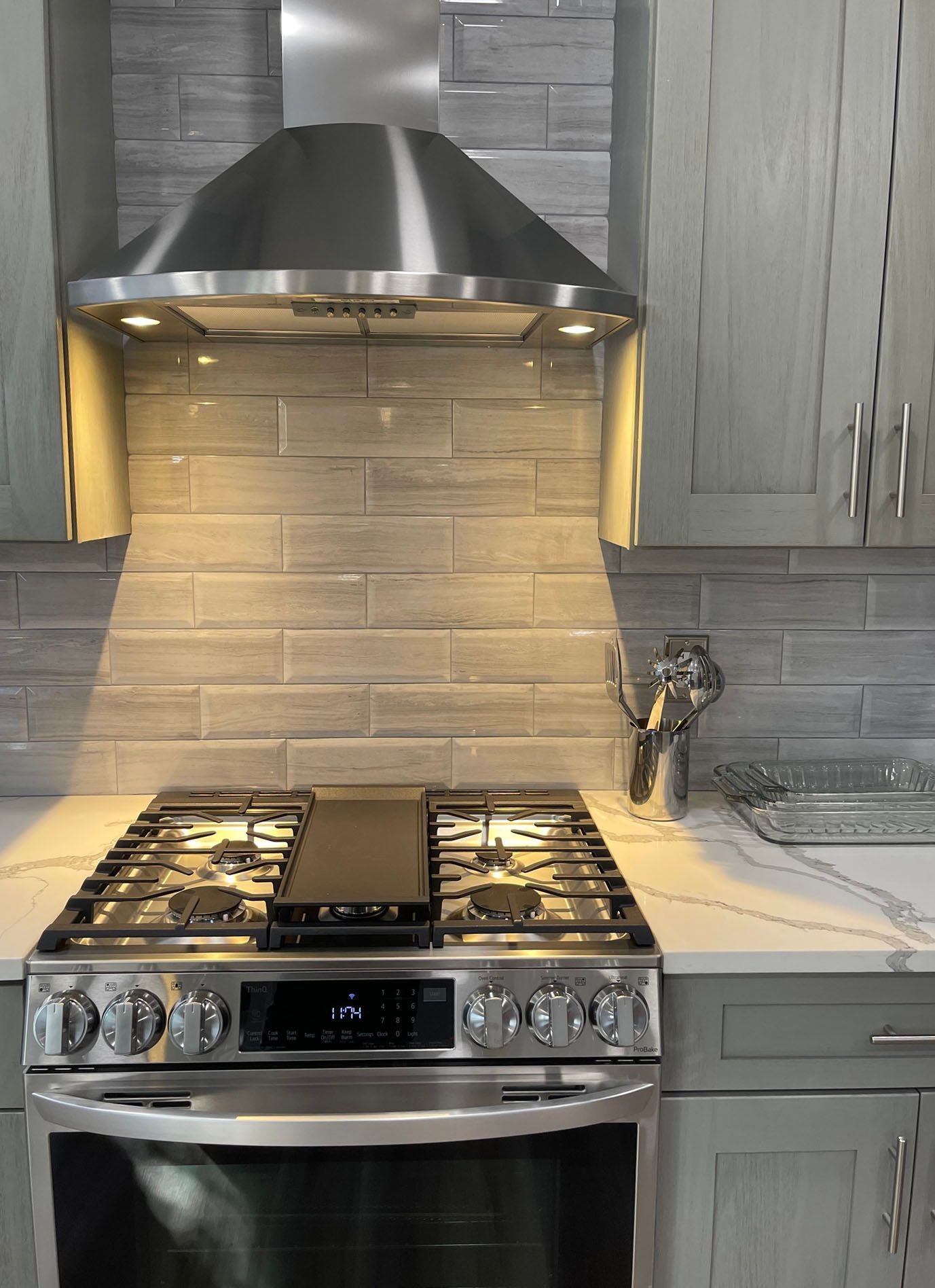 A kitchen with a stove top oven and a hood above it