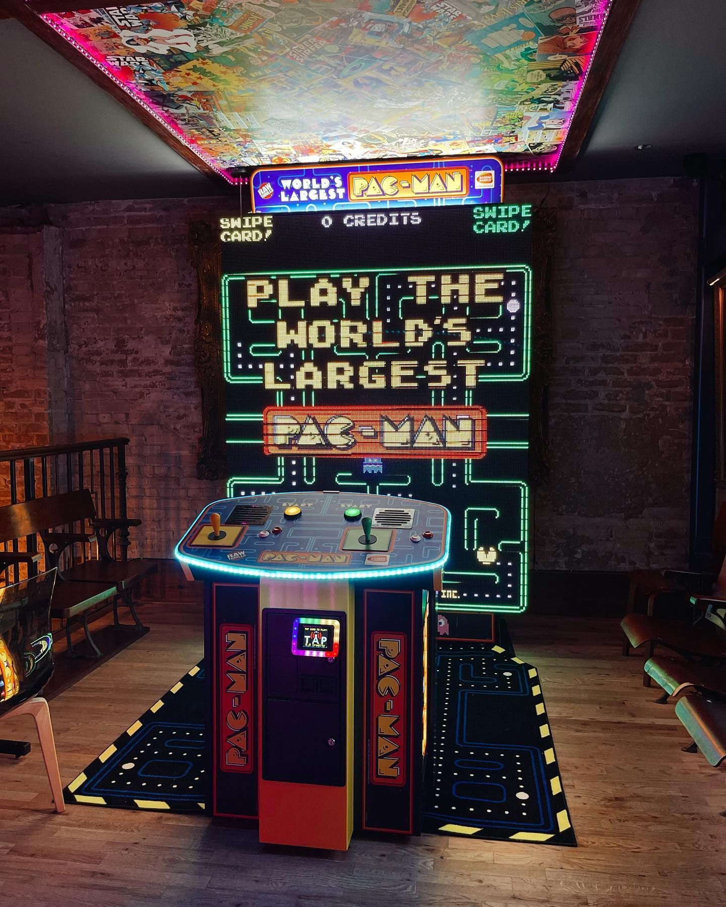 a PAC-MAN arcade game is lit up in a dark room