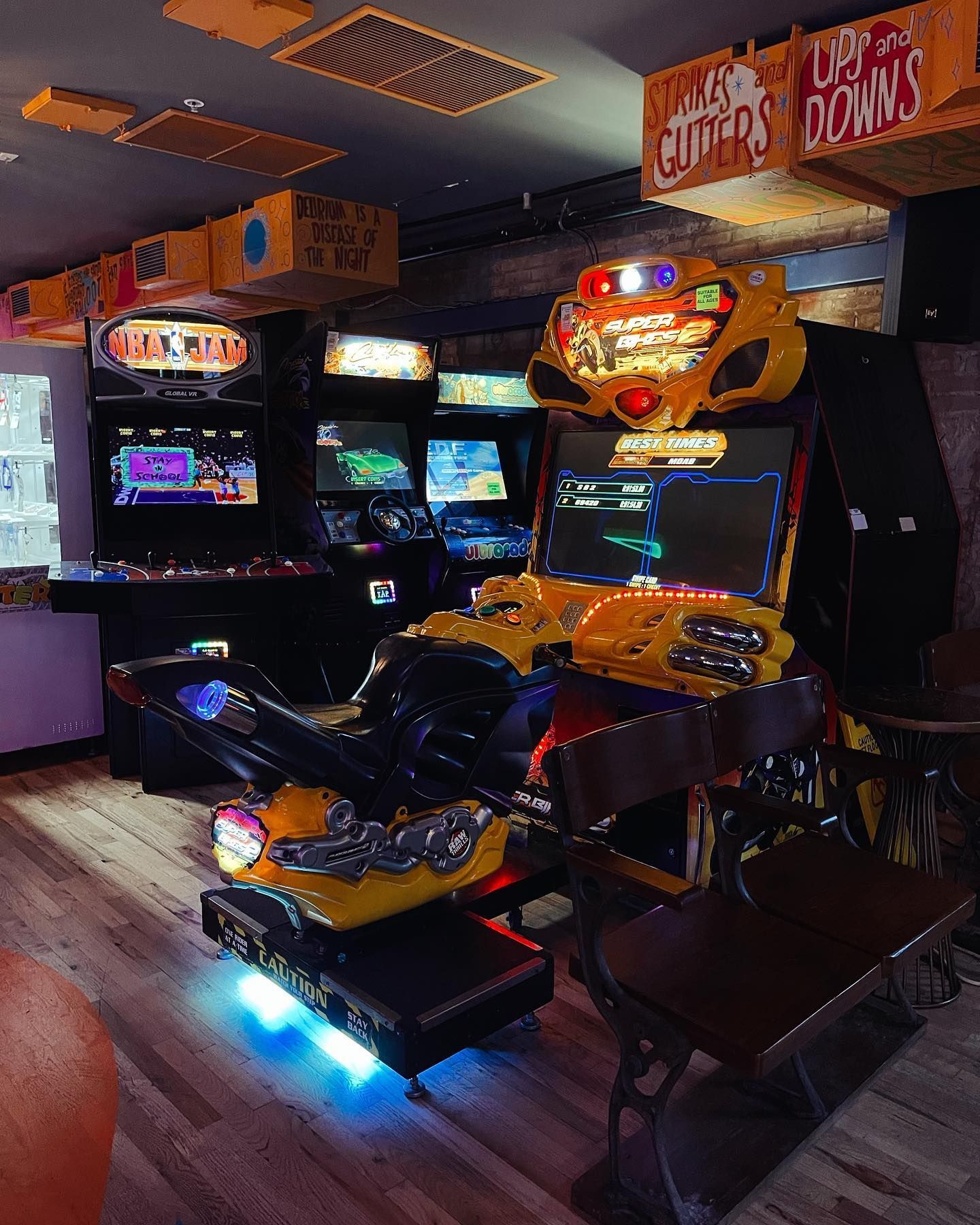 a room filled with lots of arcade games including a motorcycle game