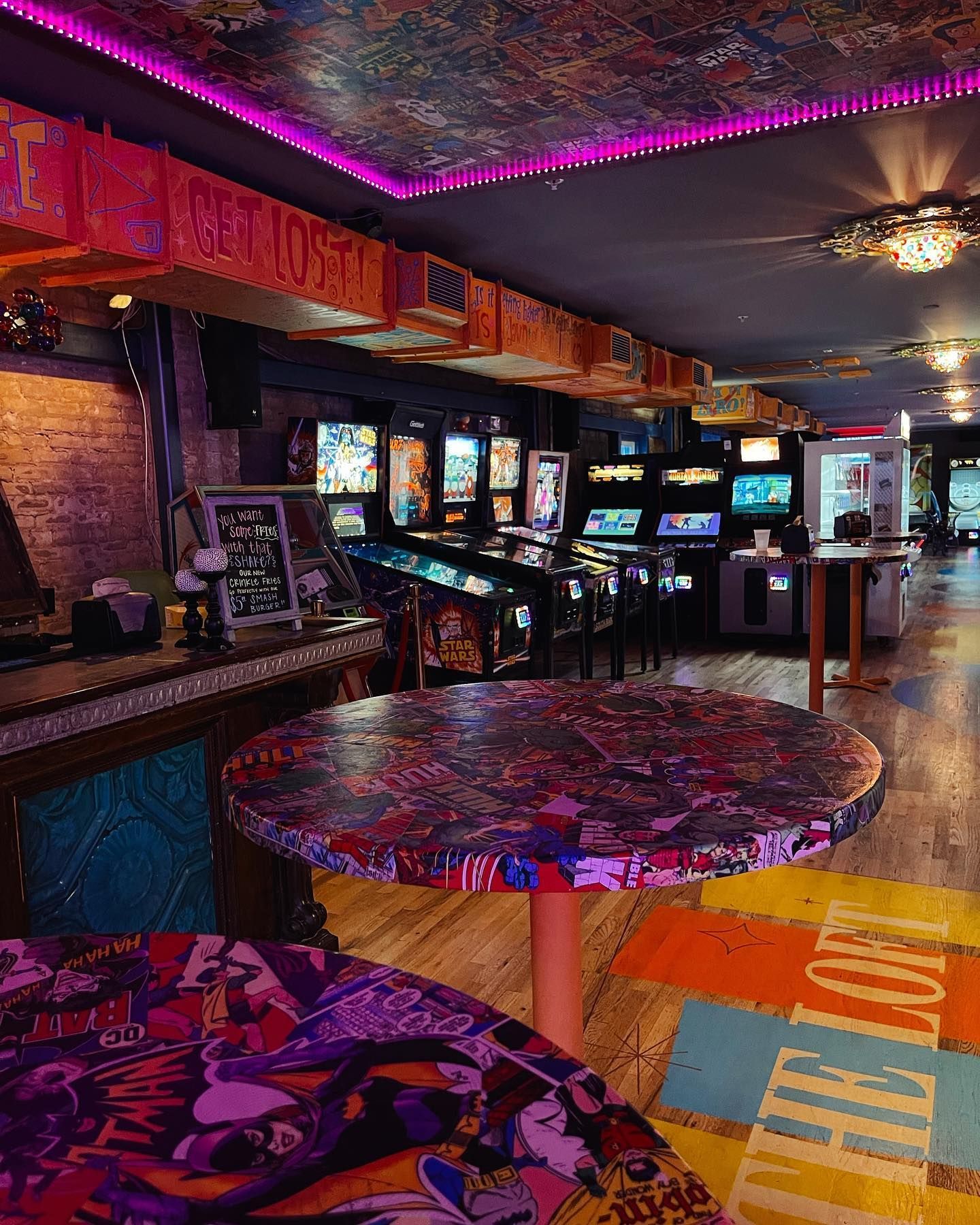 a room filled with lots of arcade games and tables