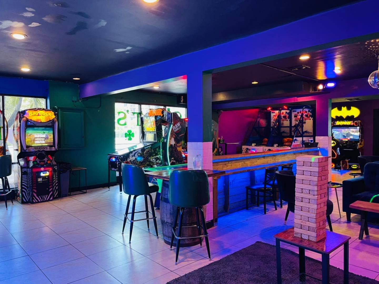 a large room with a lot of tables and chairs and a batman sign on the wall