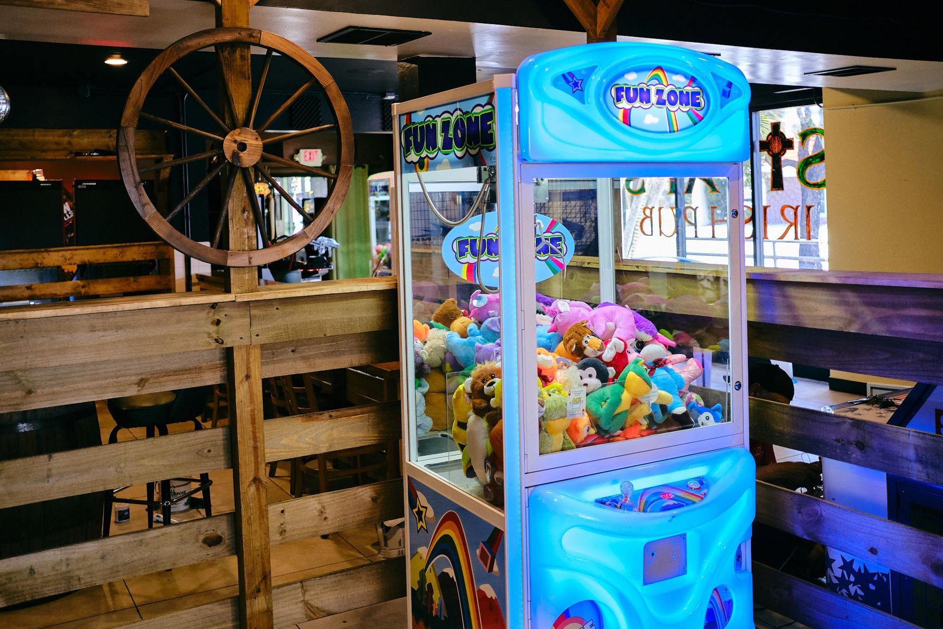 a blue claw machine filled with stuffed animals in a room