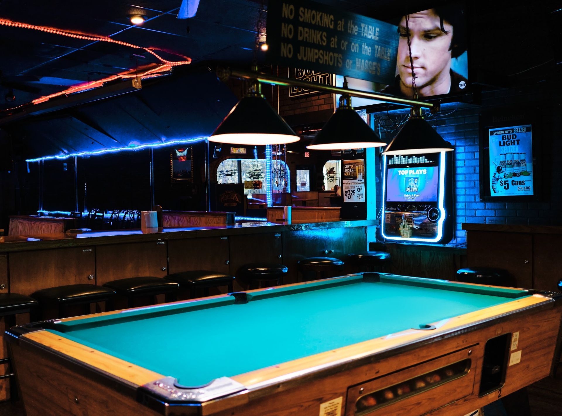 a pool table with a picture of Elvis Presley on the wall
