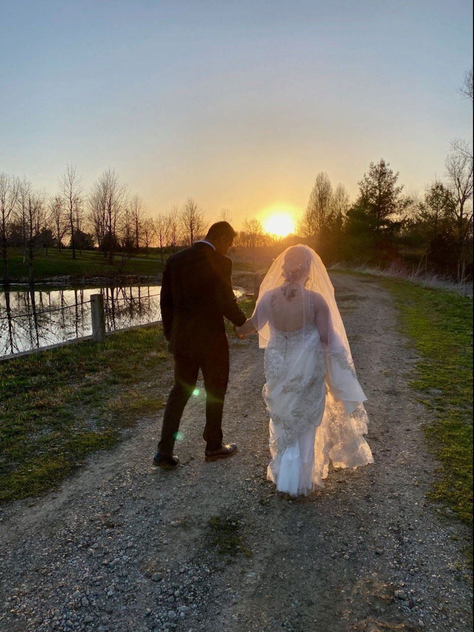 Bride and groom walking towards the sunset