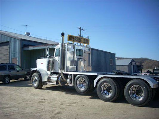 a semi truck with a yellow sign on top that says oversize load