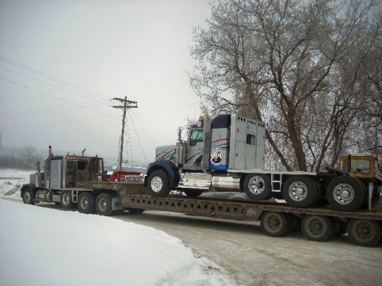 a semi truck is on a trailer in the snow