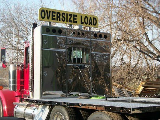 an oversize load sign is above the back of a semi truck