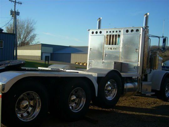 a silver semi truck is parked in front of a building