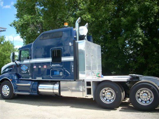 a blue semi truck is parked in a parking lot
