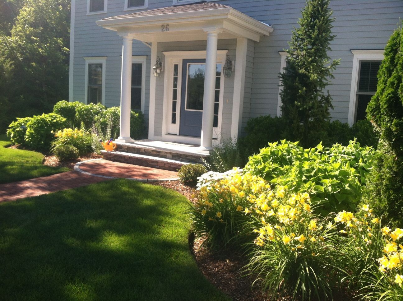 A house with a porch and a brick walkway