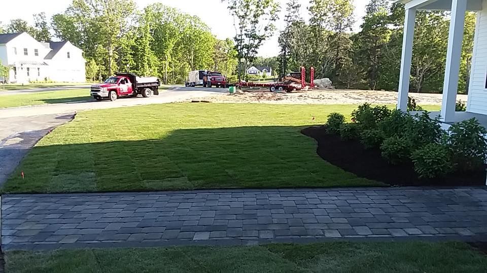 A red truck is parked in the driveway of a house
