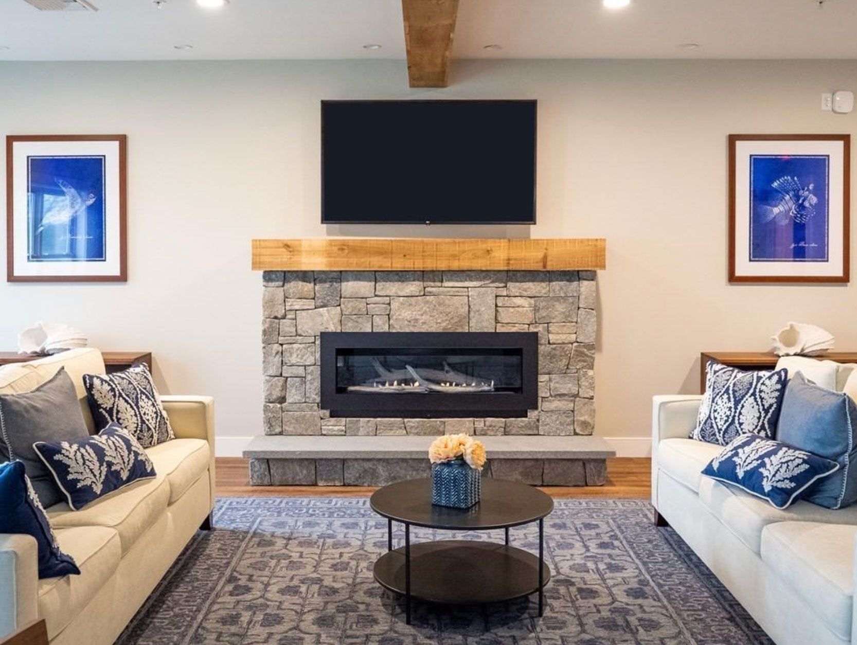 A living room with two couches, a fireplace and a flat screen tv