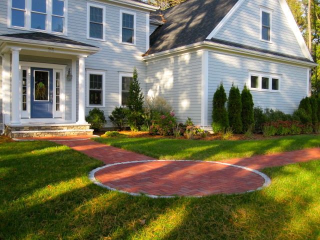 A white house with a red walkway in front of it
