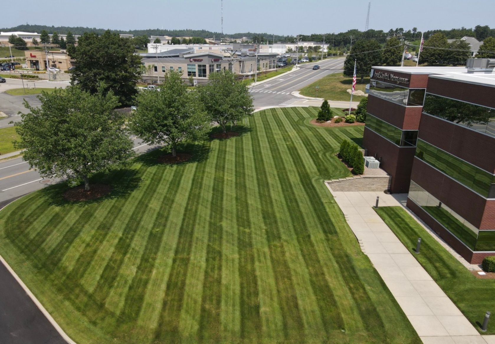 An aerial view of a lush green lawn in front of a building