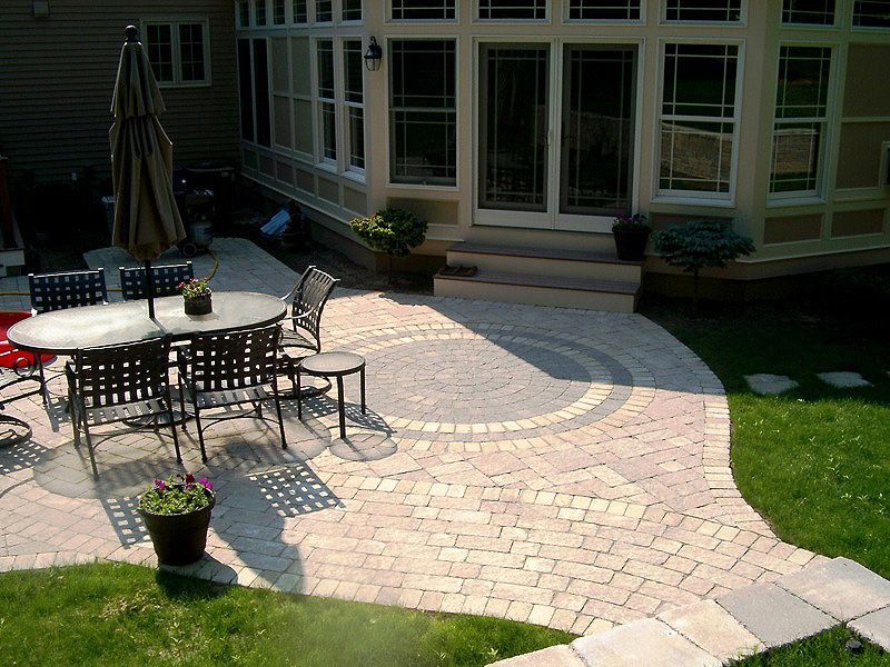 A patio with a table and chairs and an umbrella