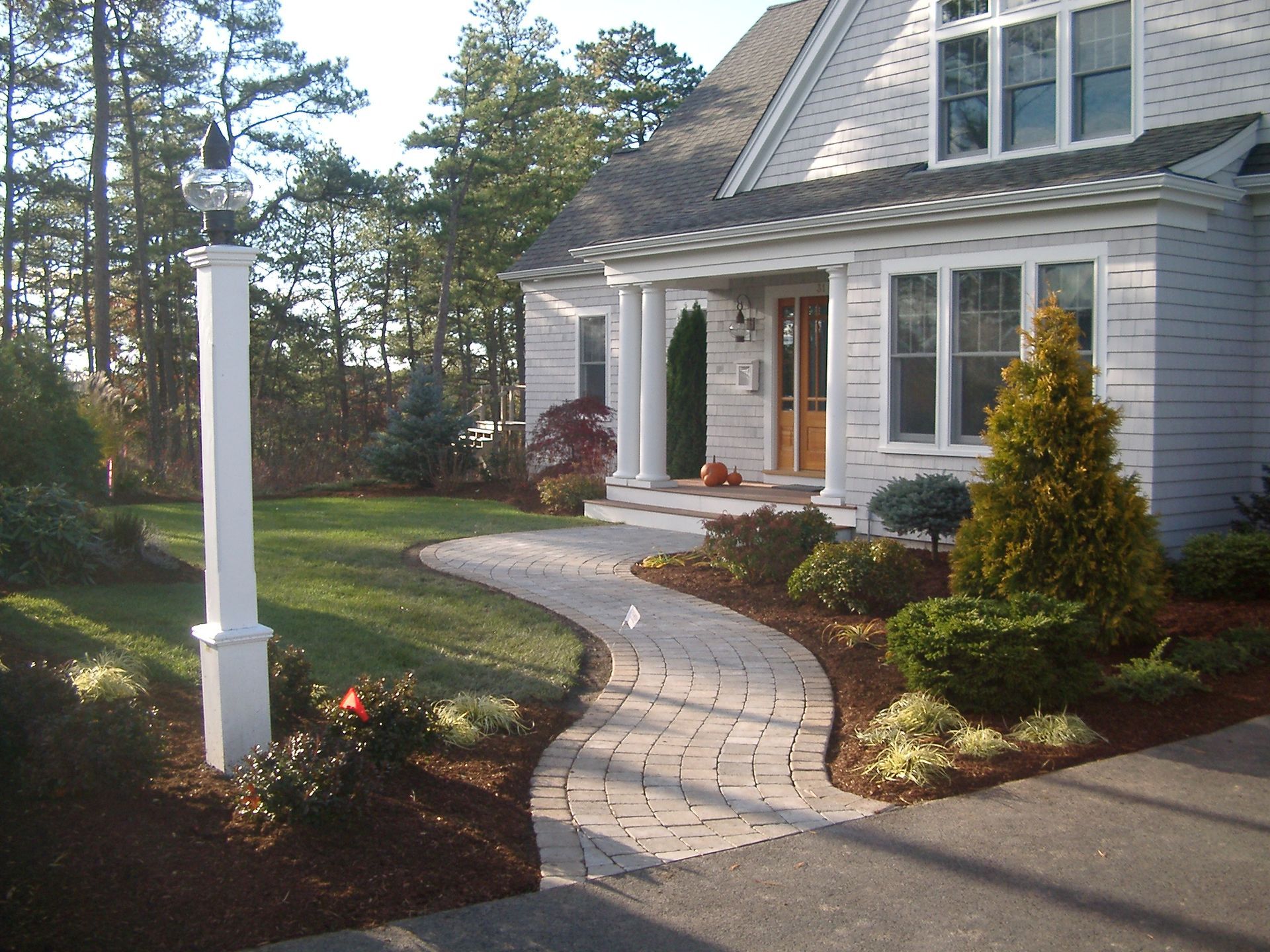 A white house with a walkway leading to the front door