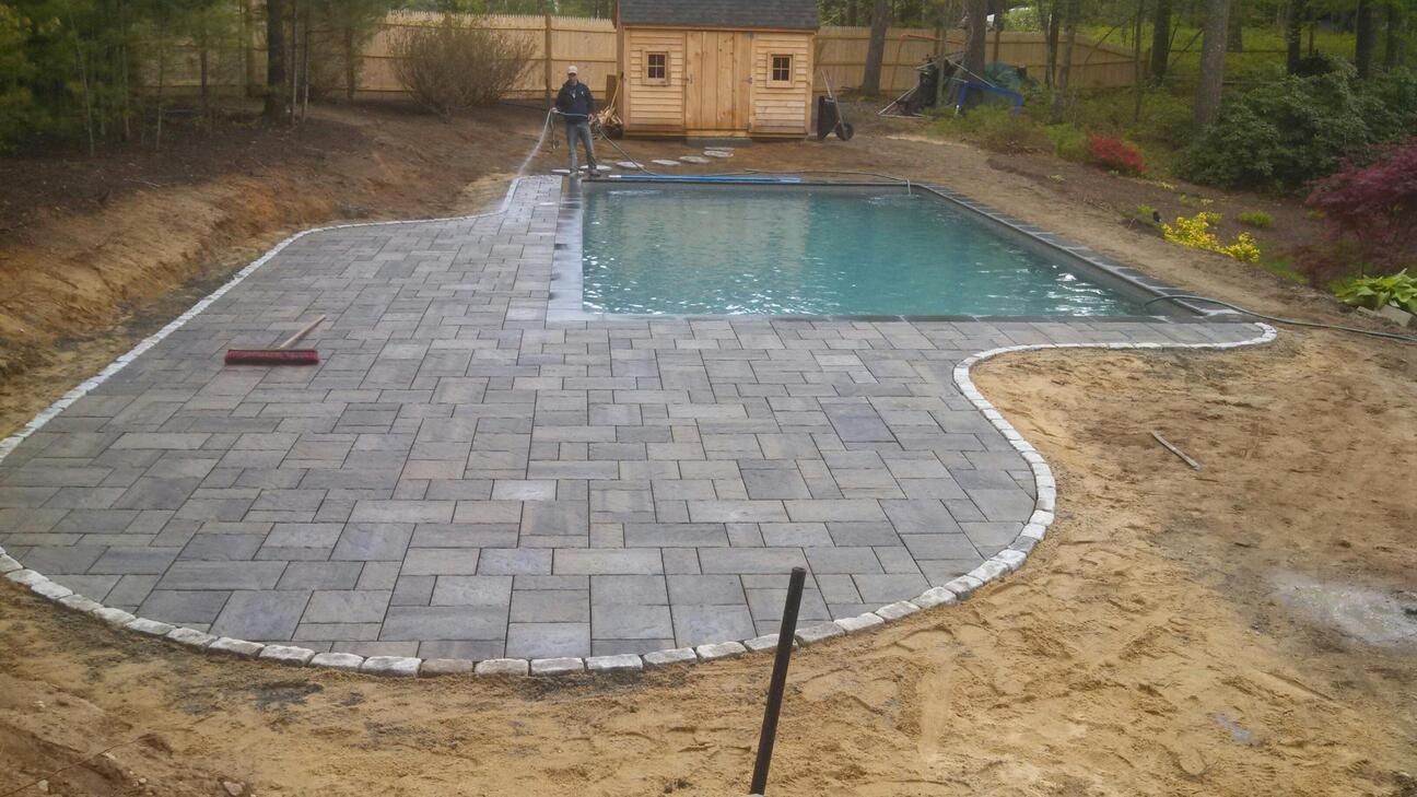 A swimming pool is being built in the backyard of a house