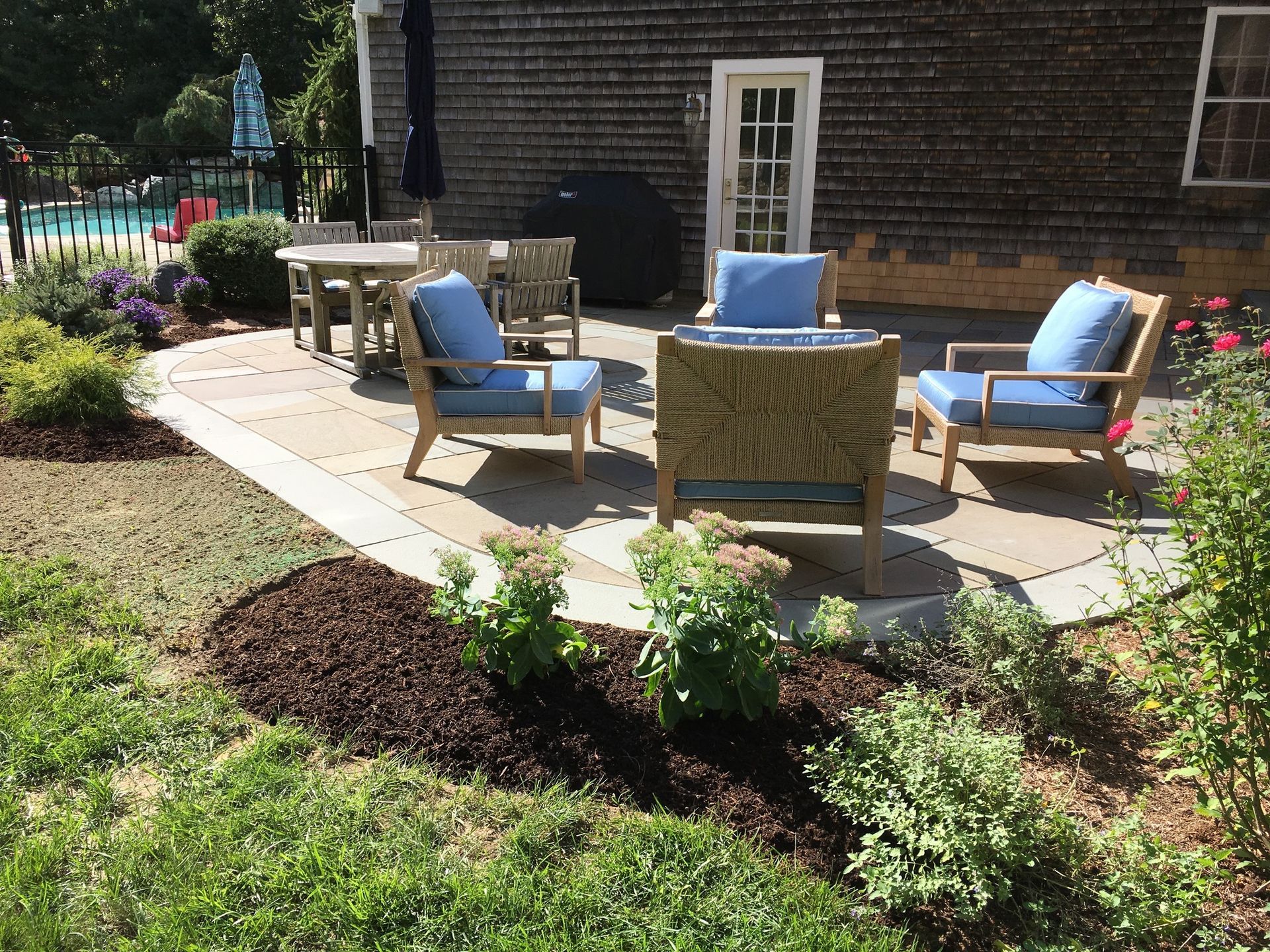 A patio with a table and chairs in front of a house