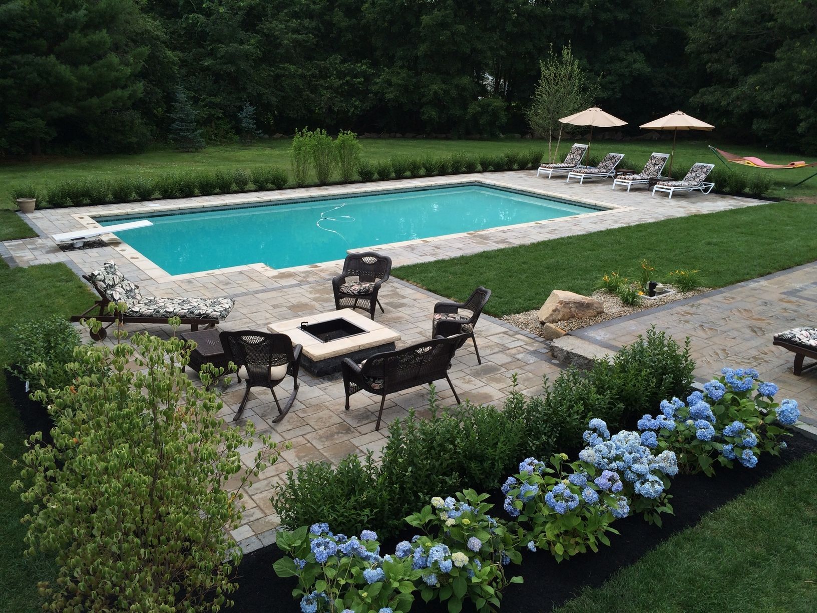 A large swimming pool surrounded by chairs and umbrellas