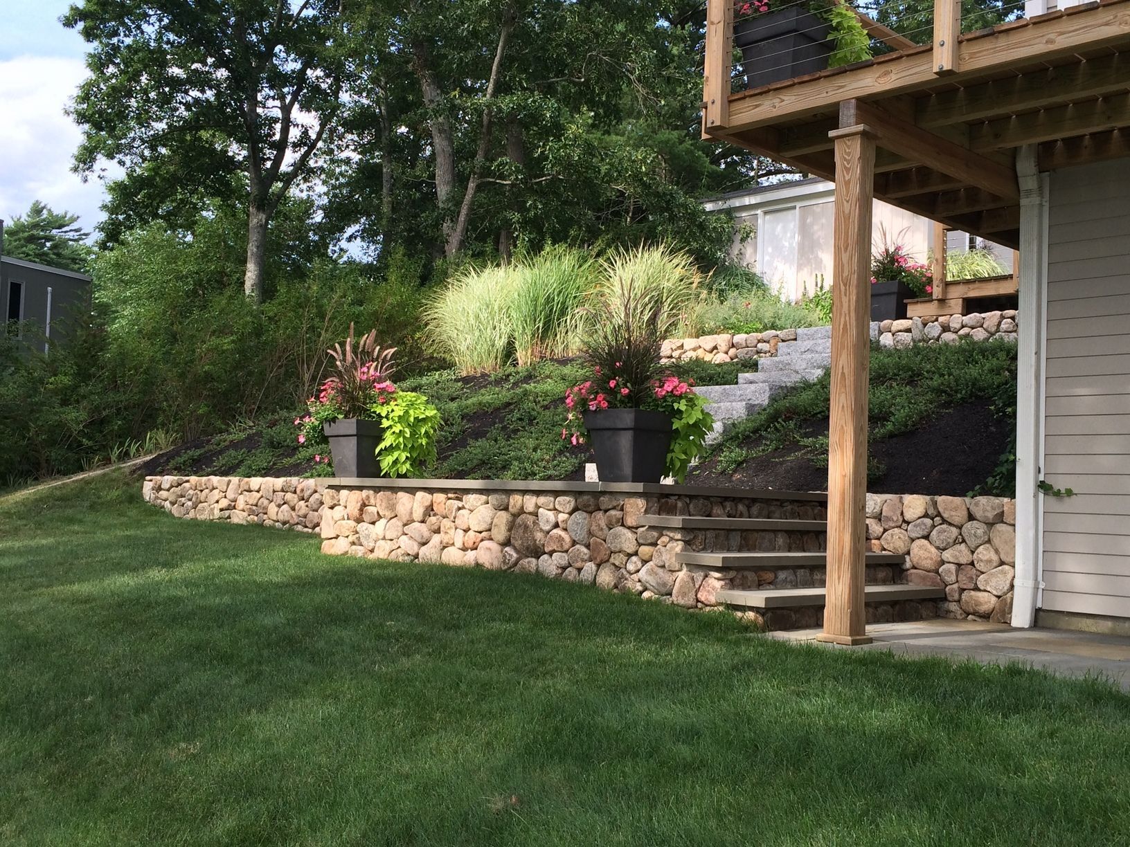 A house with a stone wall and stairs leading up to it