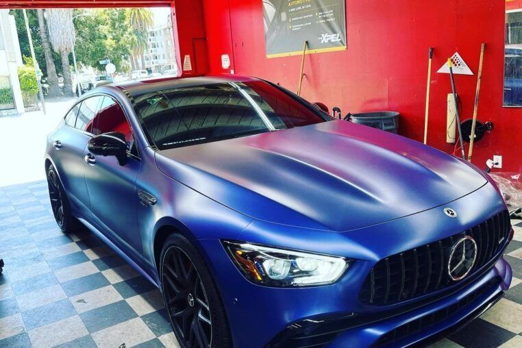 Blue Mercedes sedan parked inside a red garage
