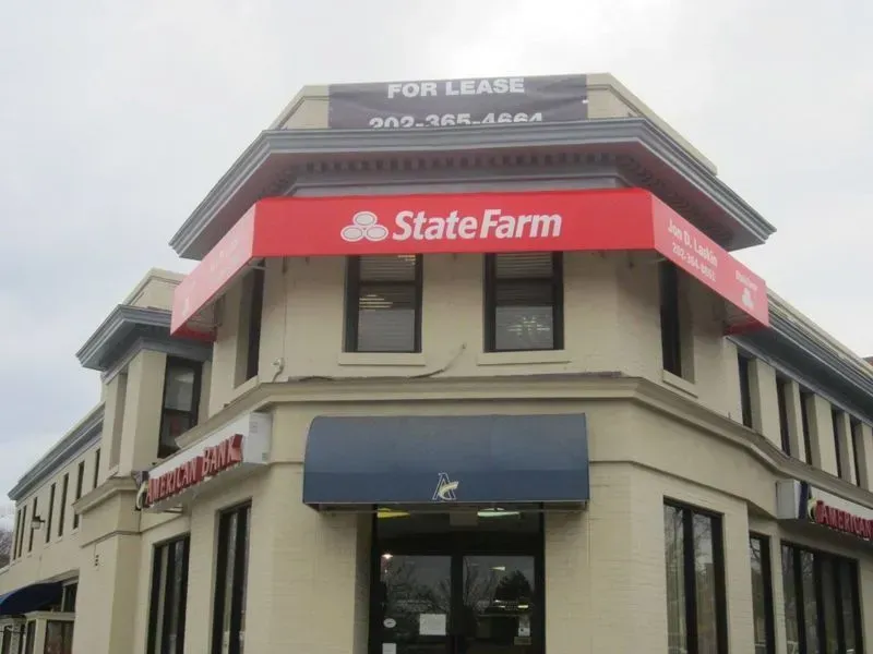 Two-story building with a red State Farm awning, a 