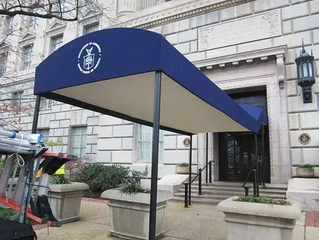 Blue awning over entrance with emblem. Stone building.