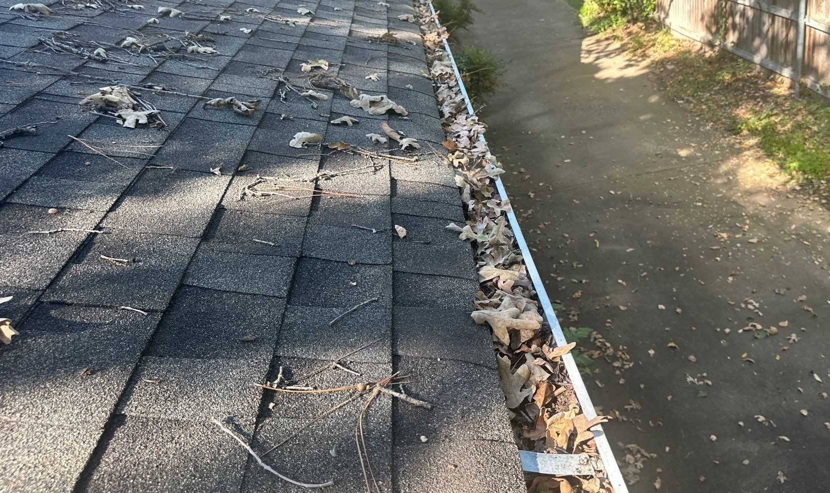 Gutters full of leaves on a house with hail damage in Fort Worth Texas - By Becker Roofing and Exteriors