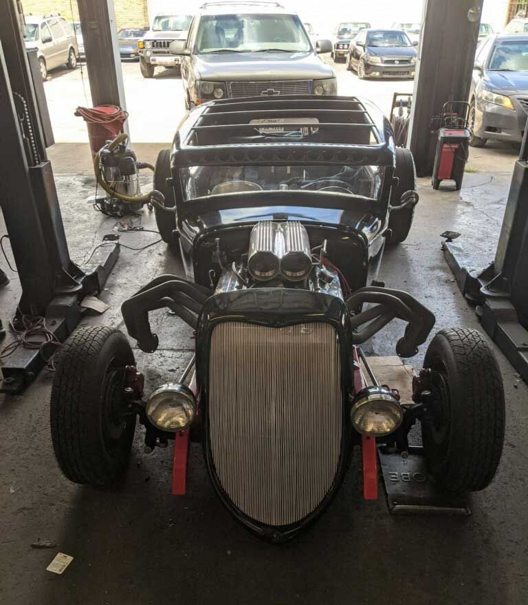 A car is sitting on a lift in a garage.