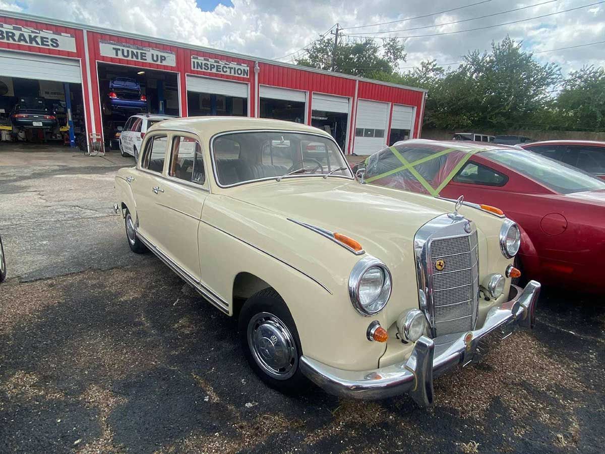 A white car is parked in front of a garage.