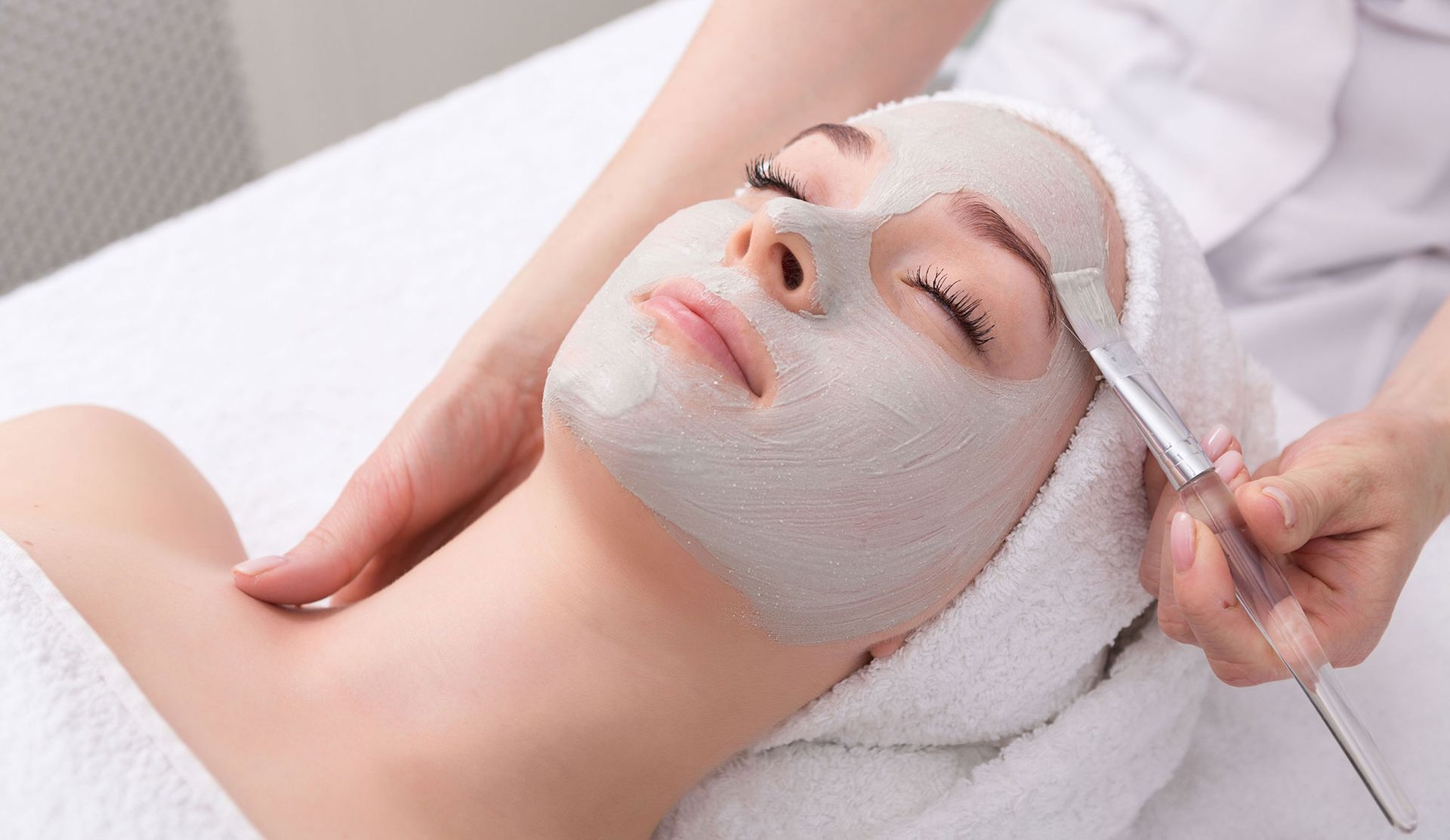 A woman is getting a botox injection in her forehead.