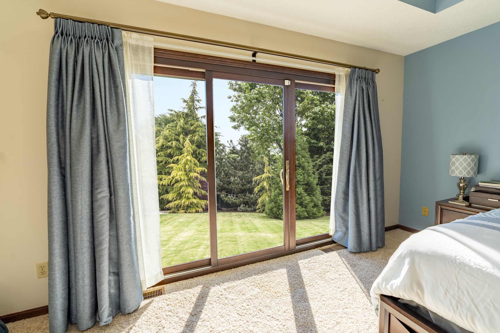 A bedroom with a sliding glass door and a bed.