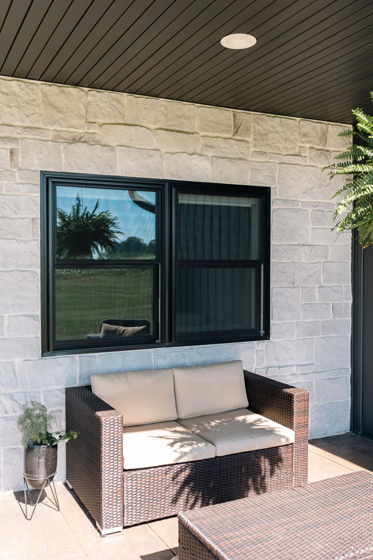 A patio with a couch , table , and window.