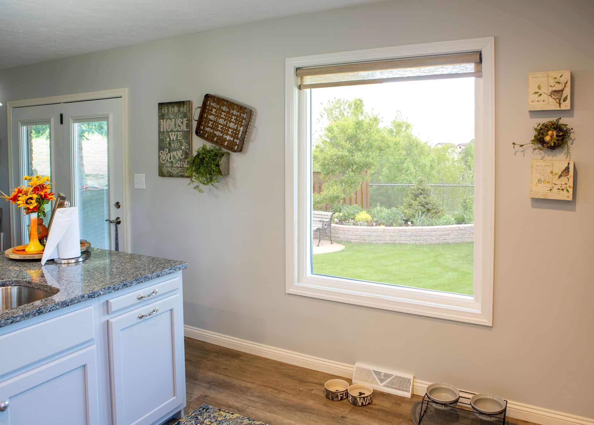 A kitchen with a large window and a sink.