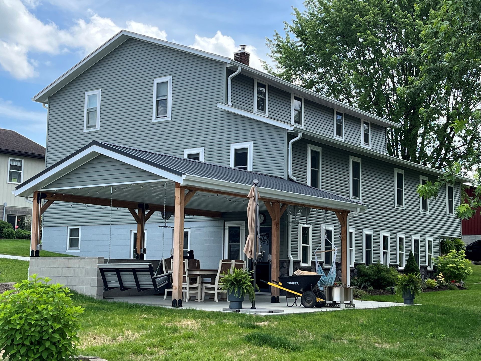 A blue siding house with windows and side patios.