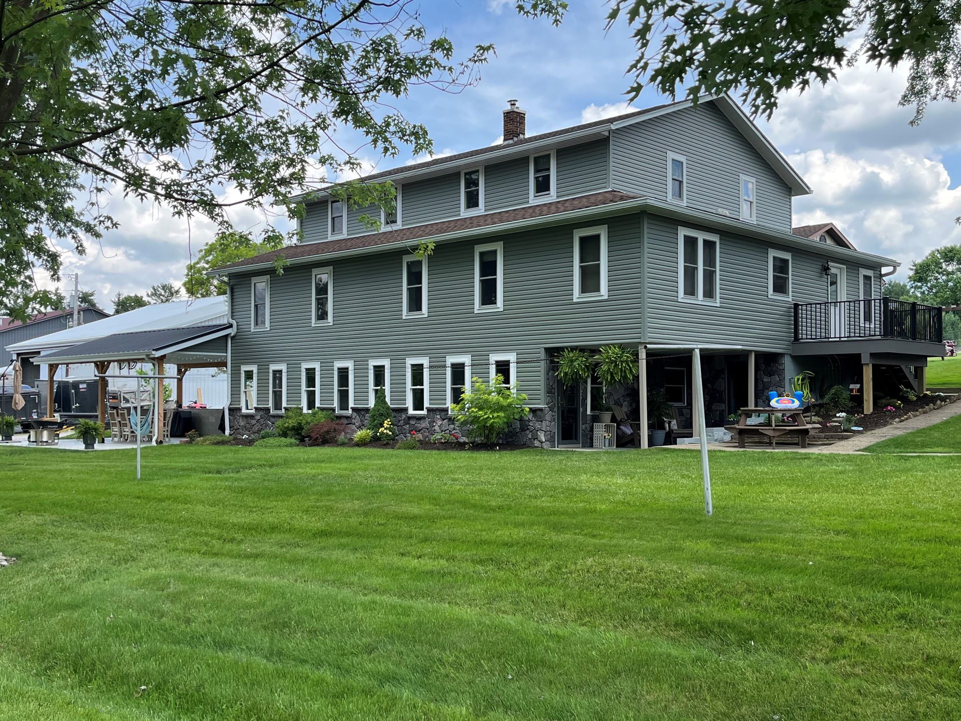 blue siding house with house with windows showing lower patio 