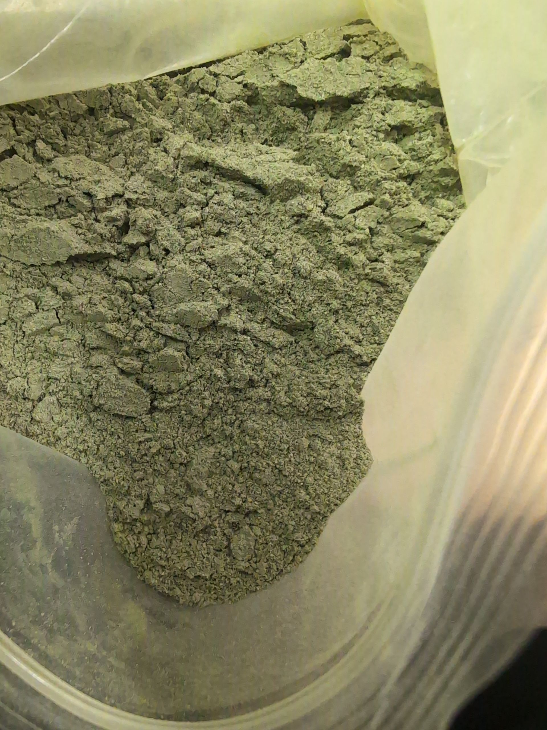 A plastic bag filled with a fine, light-green powder.