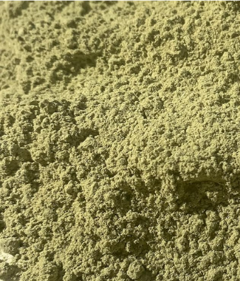 Green powder, possibly a herb or spice, with a coarse texture.
