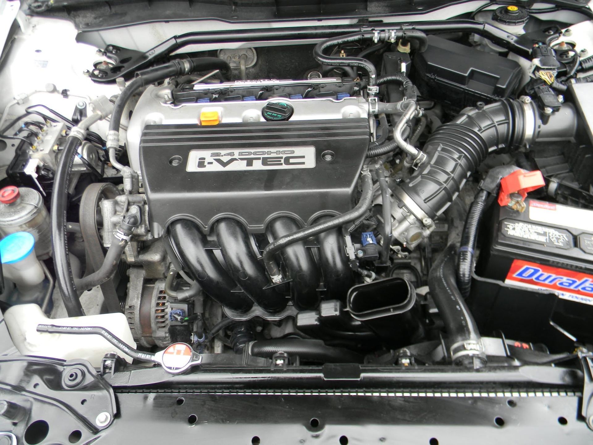 Car engine bay with Honda VTEC engine cover and black intake manifold