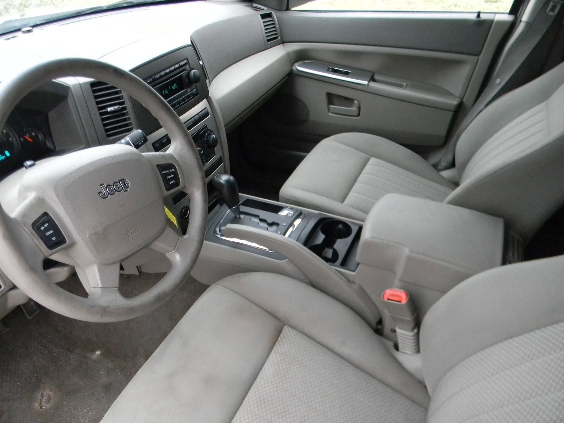 Gray car interior with steering wheel, front seats, center console, and passenger-side door panel