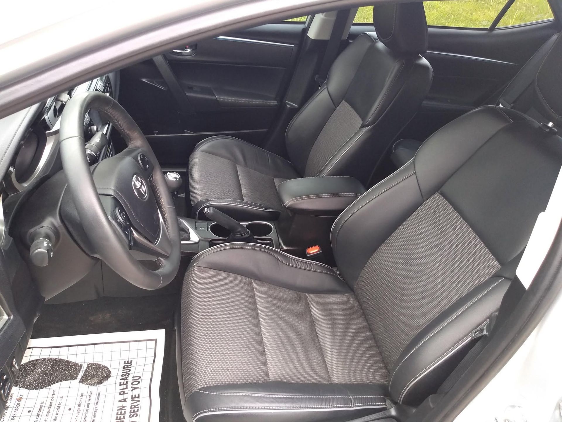Car interior with black leather front seats, steering wheel, and center console.