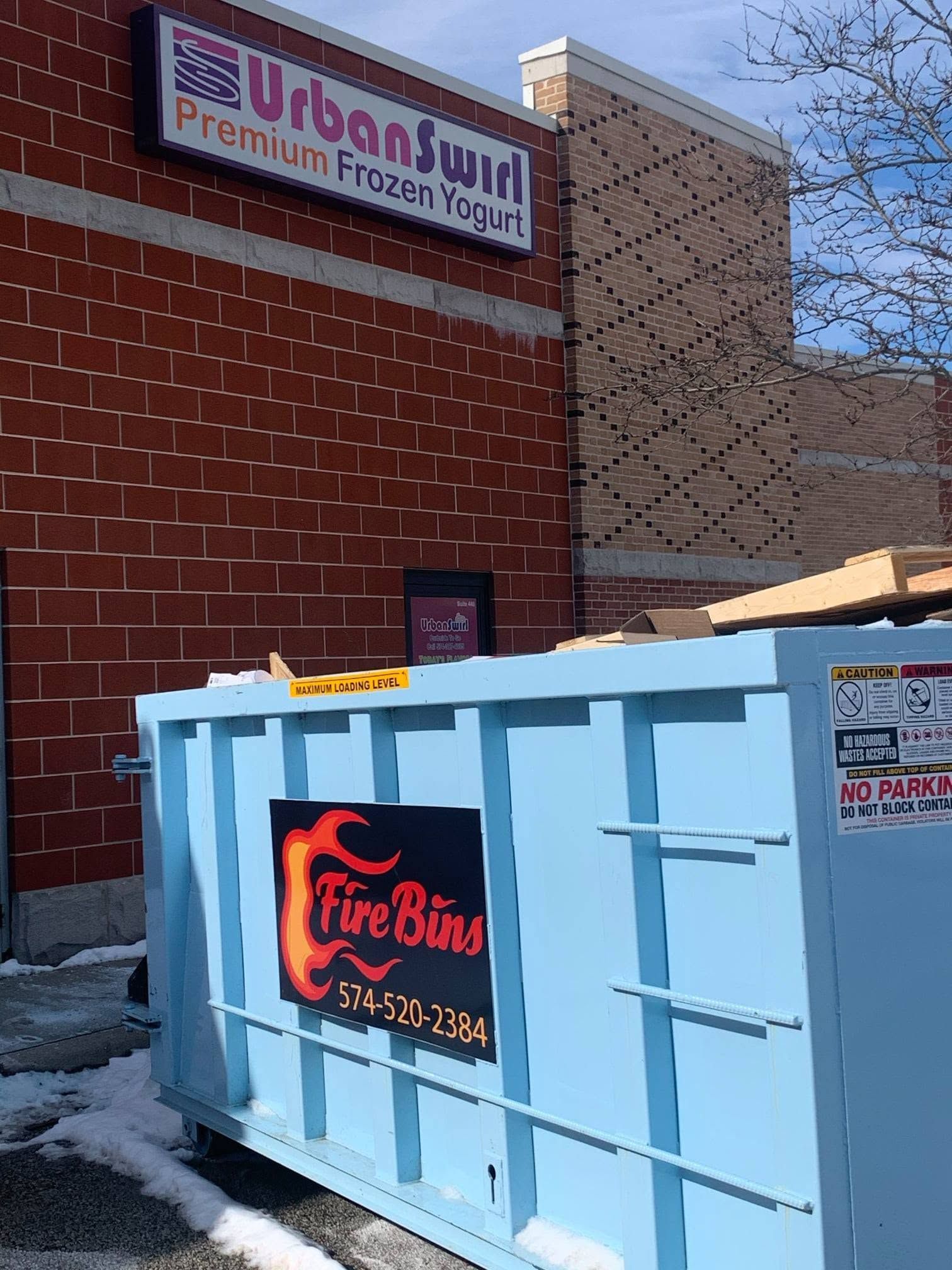 Blue FireBin dumpster outside Urban Turf Premium Frozen Yogurt storefront in snowy alley